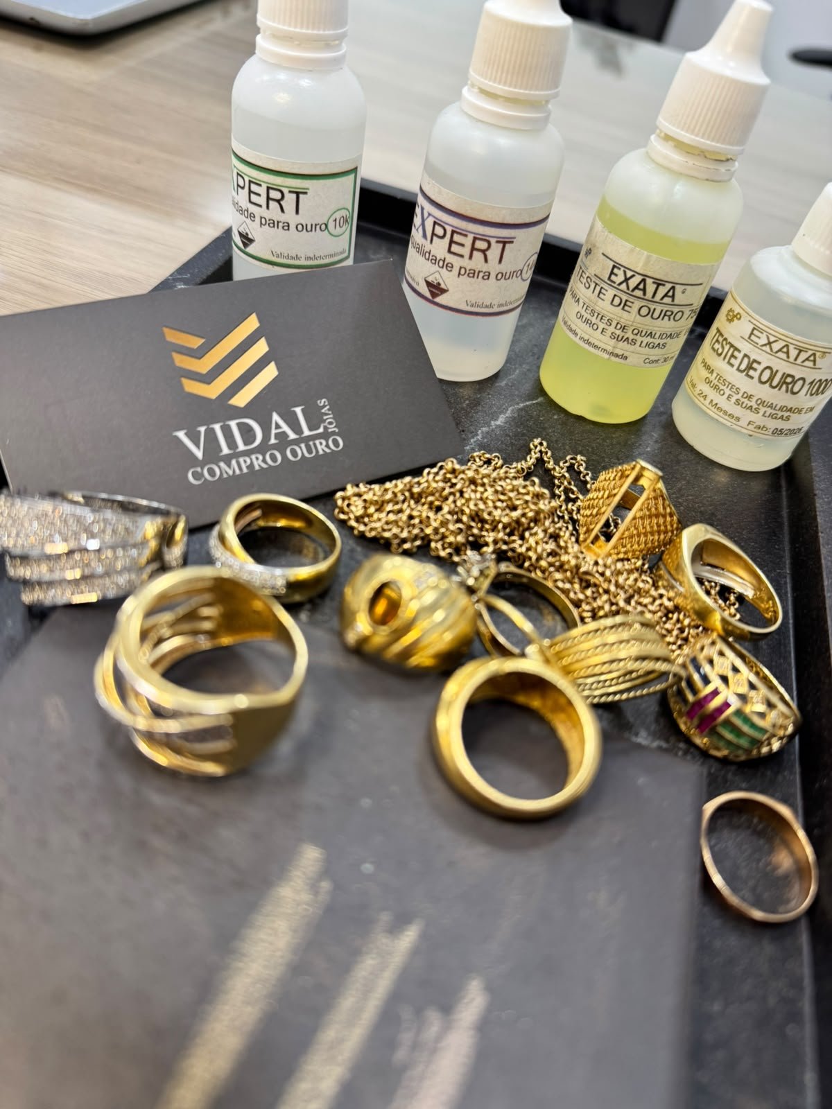 Joias de ouro e materiais de teste sobre a bancada da Vidal Joias